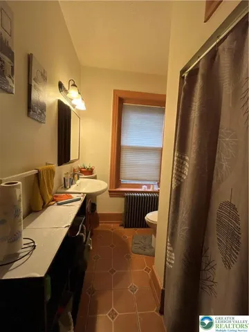 a bathroom with a tub sink and mirror