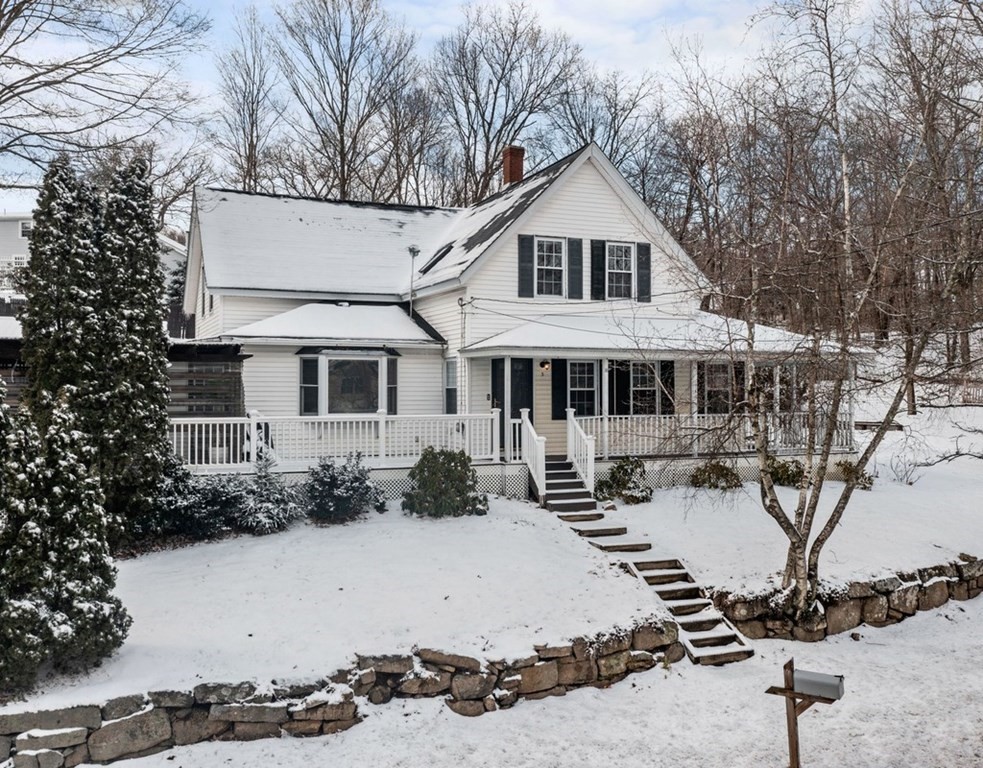 a front view of a house with a yard covered with snow