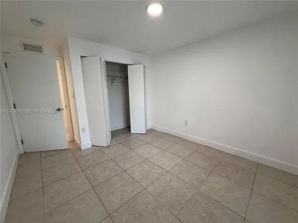 a view of an empty room with closet area