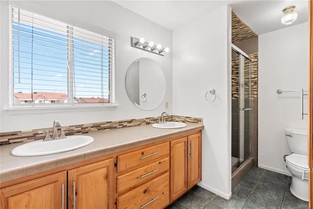 a bathroom with a granite countertop sink mirror and a toilet