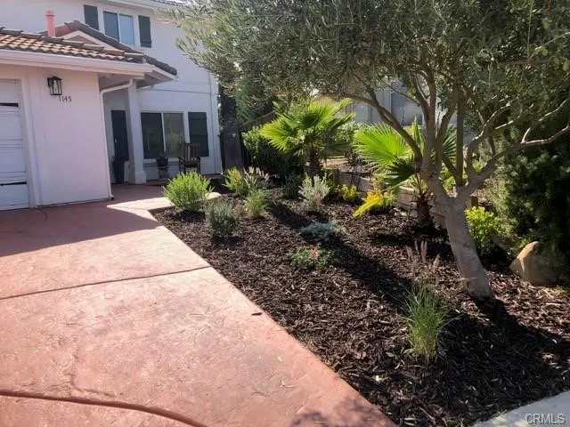 a view of a house with a yard and potted plants