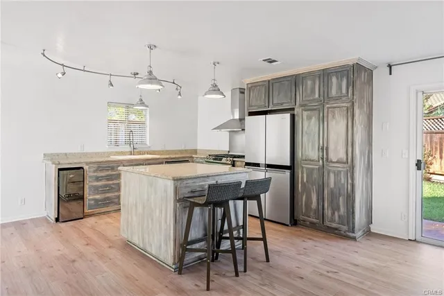 a kitchen with kitchen island a counter top space a sink stainless steel appliances and cabinets