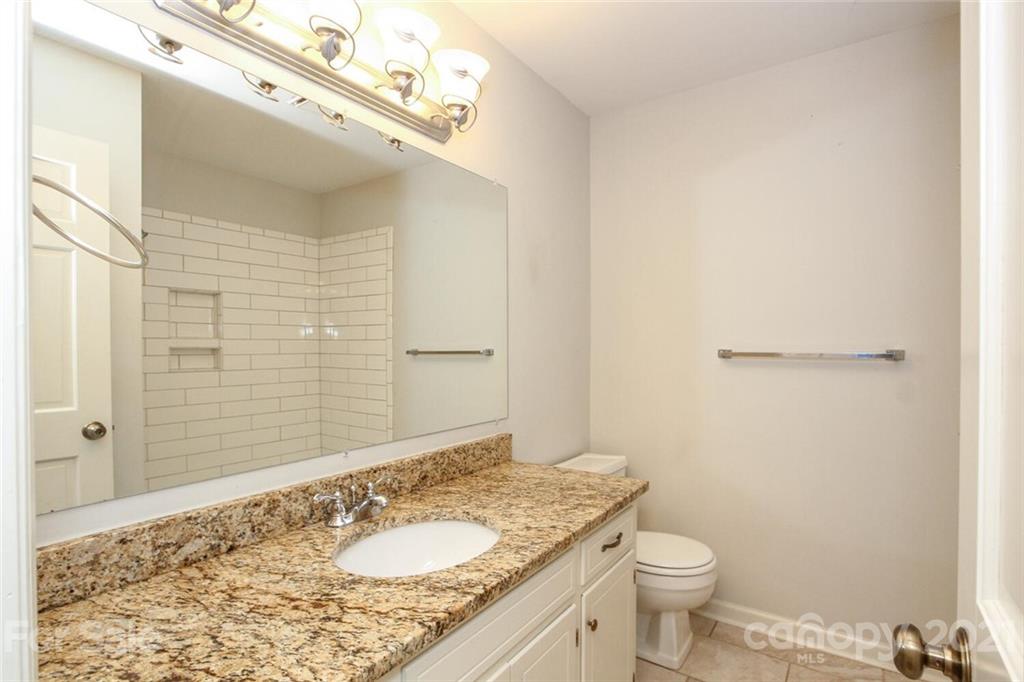 6204 Potter Road Matthews, NC 28104 - Photo 23 of 31 a bathroom with a granite countertop sink toilet and shower