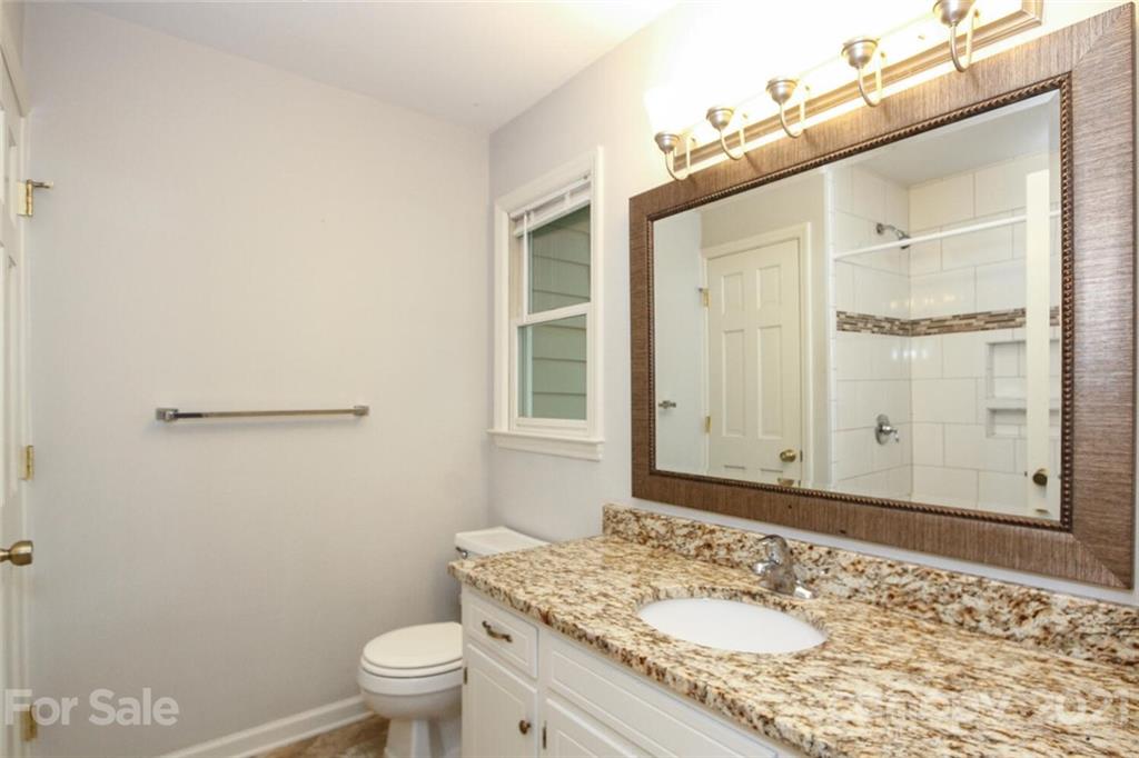 6204 Potter Road Matthews, NC 28104 - Photo 27 of 31 a bathroom with a granite countertop sink a toilet and a mirror