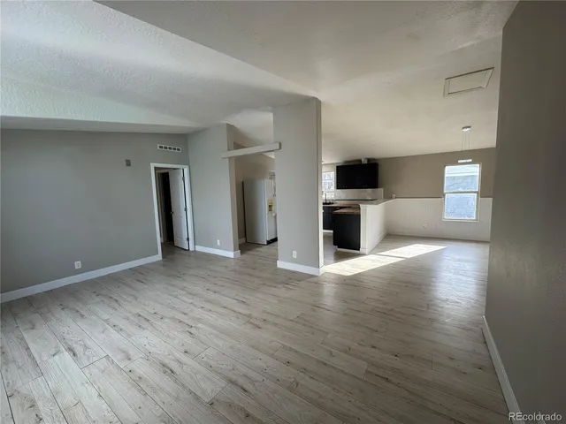 a view of a livingroom with wooden floor and a sink