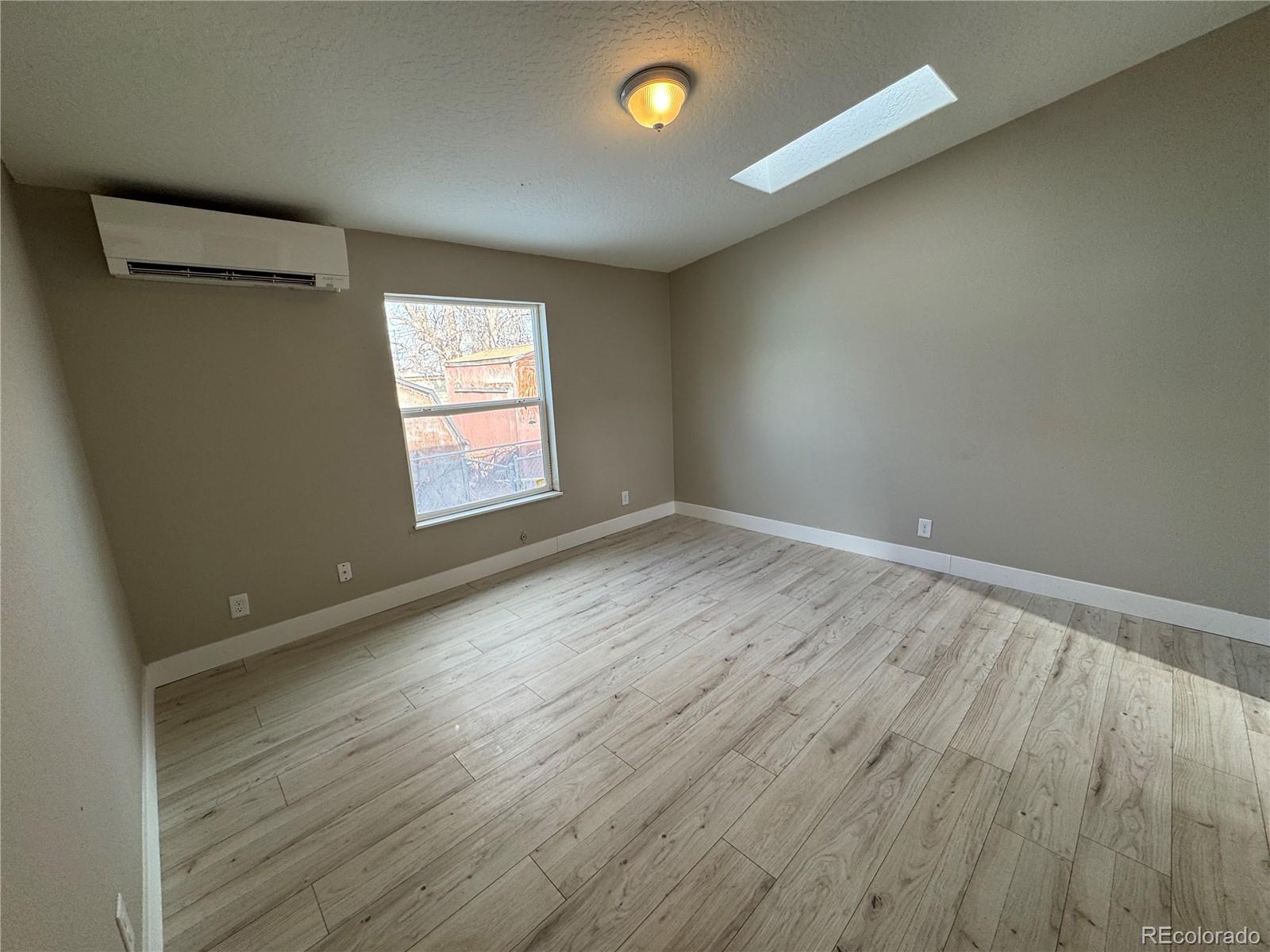 475 Pierce Street Erie, CO 80516 - Photo 5 of 16 an empty room with wooden floor and windows