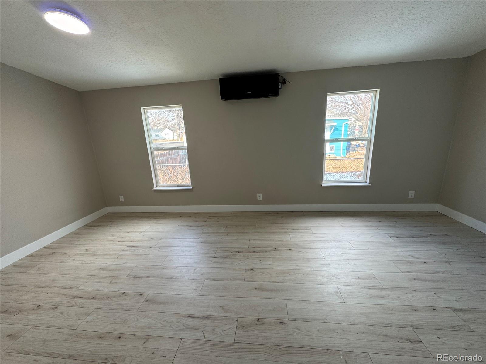 475 Pierce Street Erie, CO 80516 - Photo 8 of 16 an empty room with wooden floor and windows