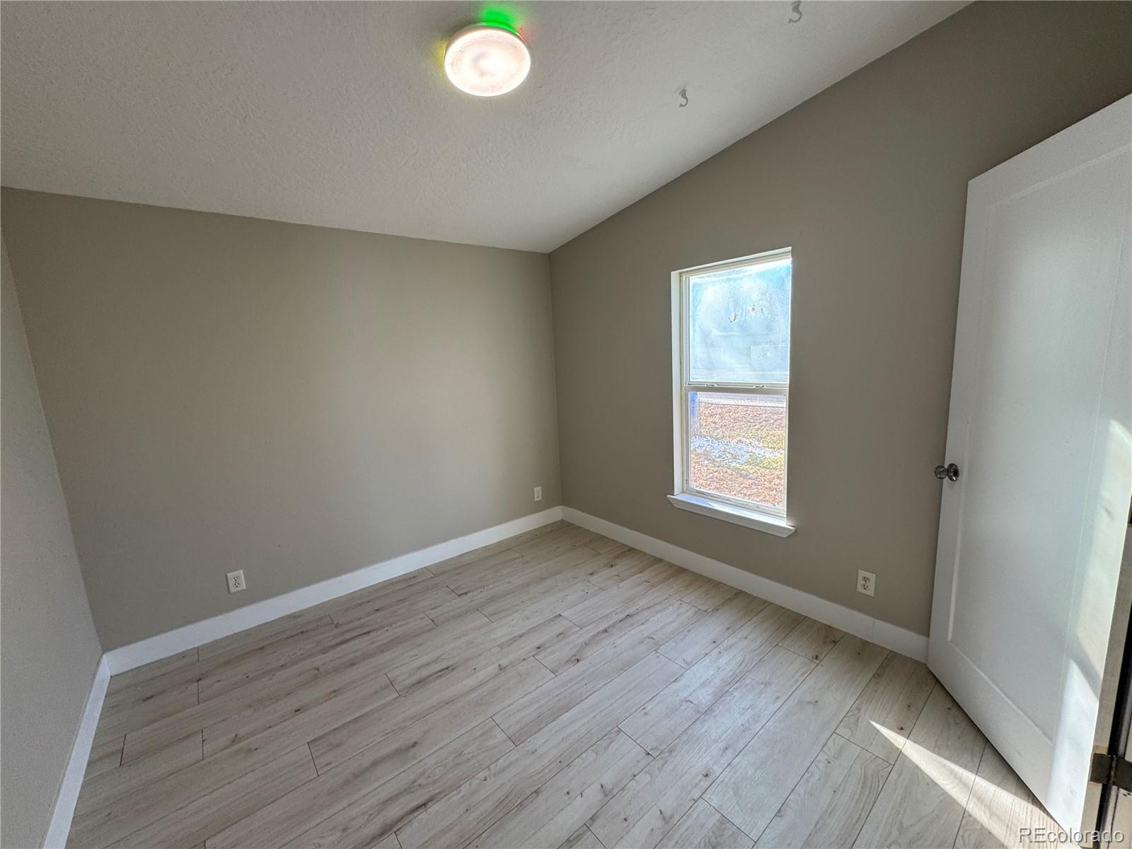 475 Pierce Street Erie, CO 80516 - Photo 9 of 16 a view of an empty room with wooden floor and a window