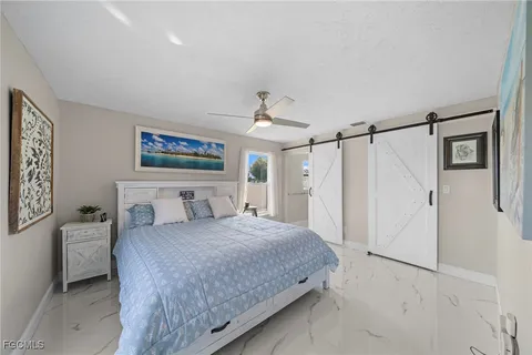 a bedroom with a large bed and a chandelier