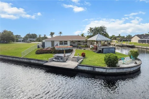 a view of a patio with lawn chairs under an umbrella