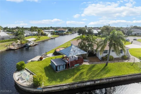 an aerial view of a house with swimming pool and lake view