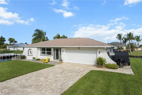 a front view of a house with a yard and trees