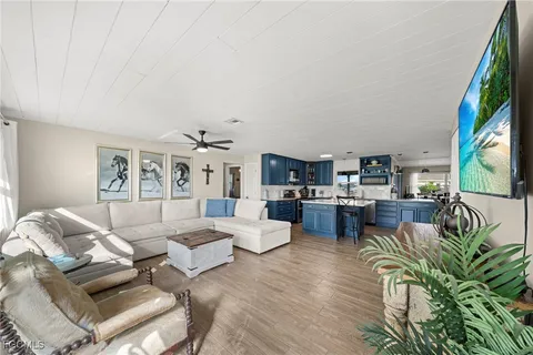 a living room with furniture a flat screen tv and a floor to ceiling window