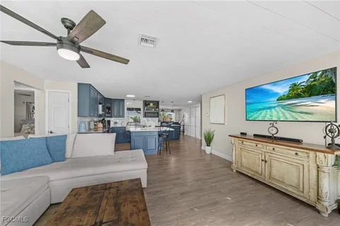 a large living room with stainless steel appliances kitchen island granite countertop furniture and a large window