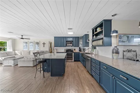 a large kitchen with stainless steel appliances granite countertop a lot of counter space and wooden floors