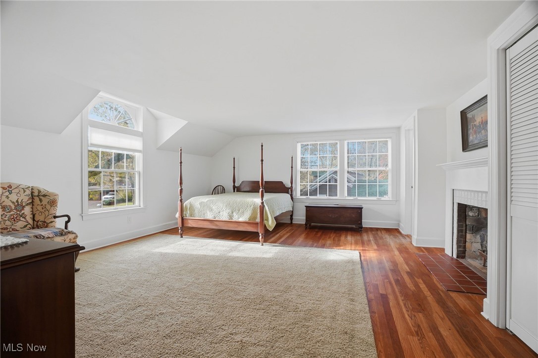 4441 Lake Road West Ashtabula, OH 44004 - Photo 22 of 46 Bedroom with wood finished floors, vaulted ceiling, and a fireplace with flush hearth