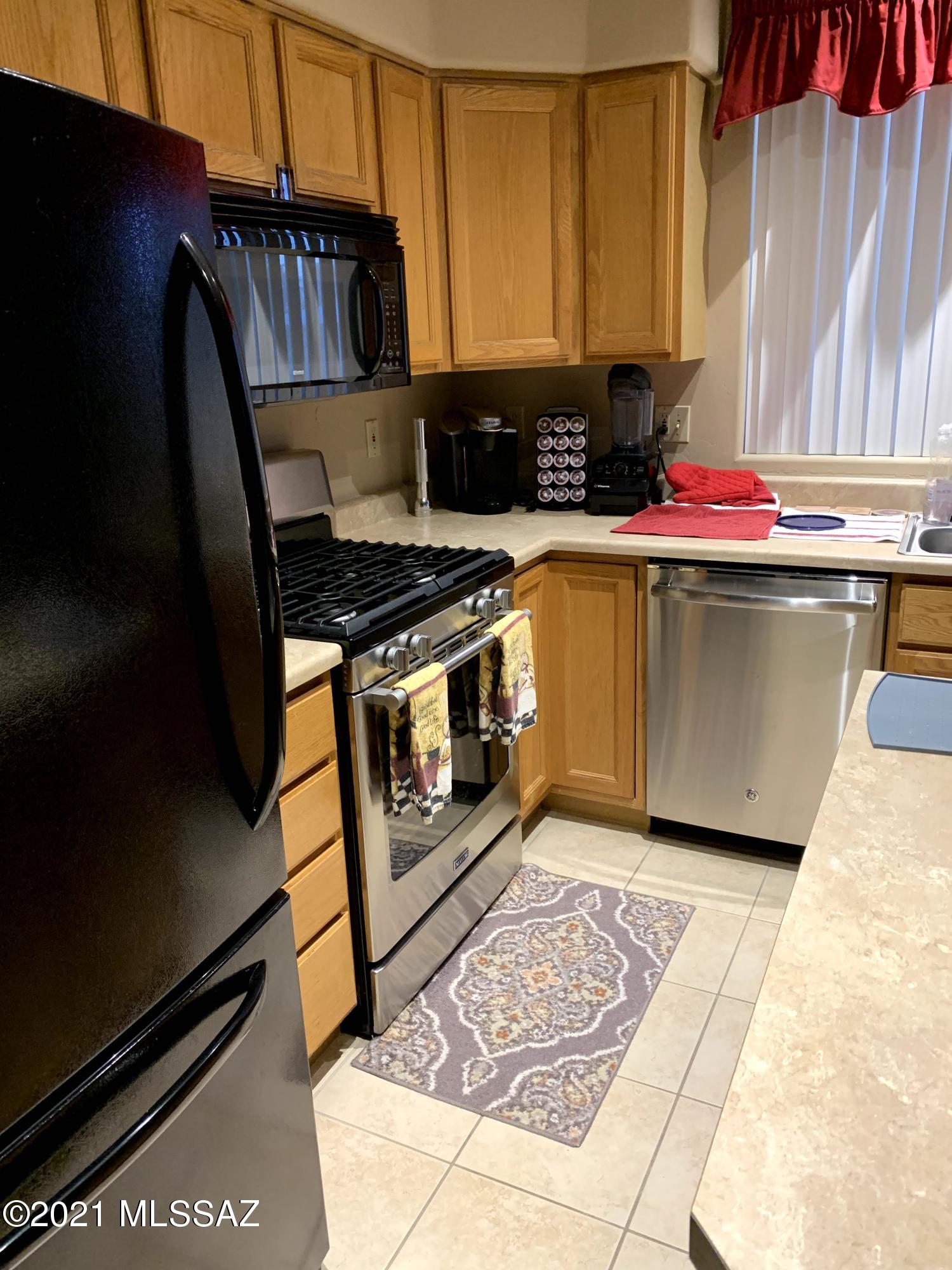 305 East Roger Road Tucson, AZ 85705 - Photo 7 of 15 a kitchen with stainless steel appliances granite countertop a stove a sink and a microwave