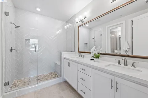 a bathroom with a double vanity sink mirror and shower