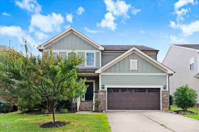 a front view of a house with a yard and garage
