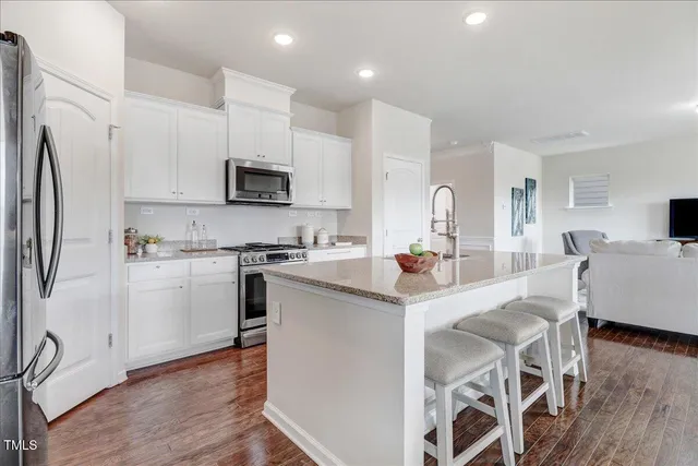 a kitchen with kitchen island granite countertop a sink and refrigerator