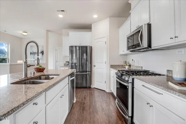 a kitchen with white cabinets and stainless steel appliances