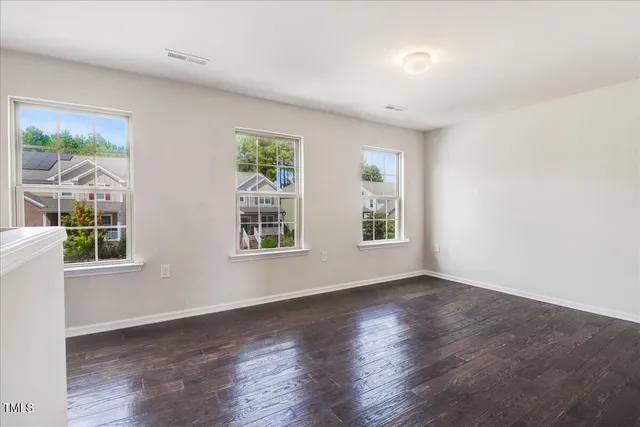 an empty room with wooden floor and cabinet