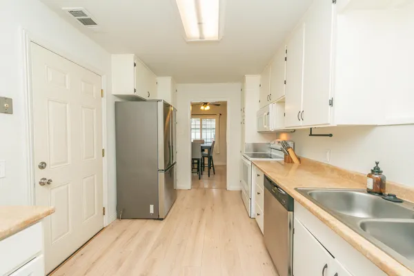 a kitchen with stainless steel appliances granite countertop a refrigerator and a sink
