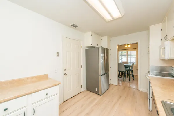 a kitchen with granite countertop a refrigerator and a stove top oven