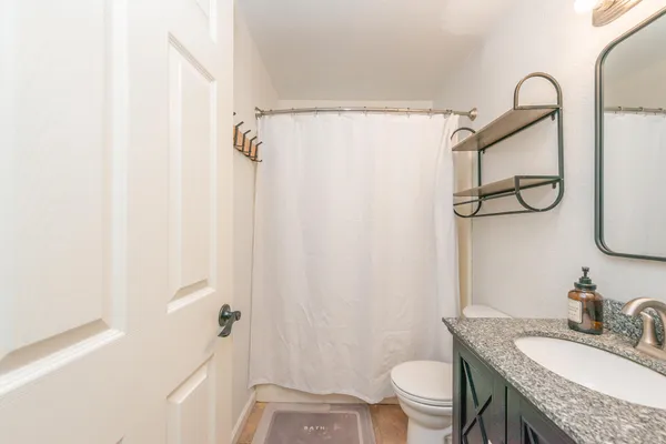 a bathroom with a granite countertop sink toilet and shower