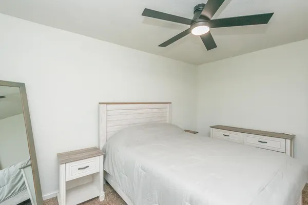 a bedroom with a bed and a ceiling fan