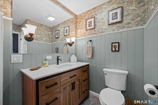 a bathroom with a toilet sink and mirror
