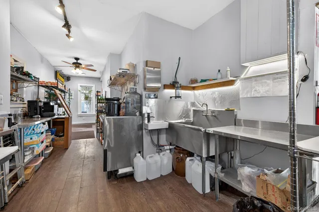 a room with stainless steel appliances lots of wooden furniture and living room view