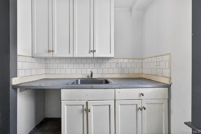 a kitchen with a sink cabinets and white countertops