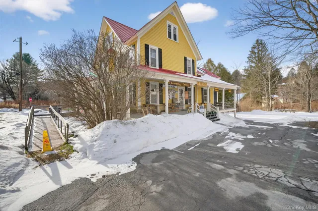 a front view of a house with a yard and trees