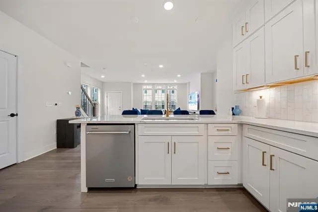 a kitchen with white cabinets and sink
