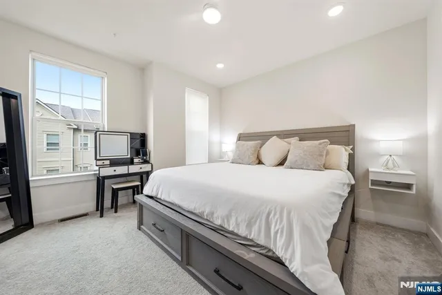 a spacious bedroom with a bed and a flat screen tv