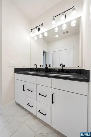 a bathroom with double sink and a mirror