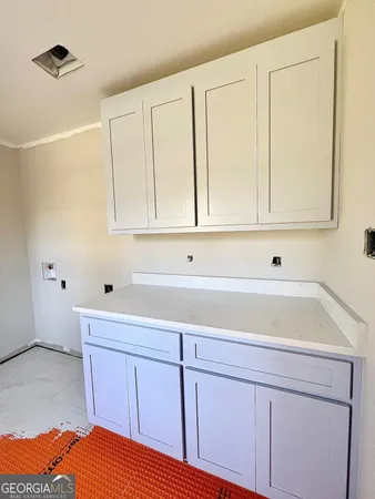 a kitchen with white cabinets and sink