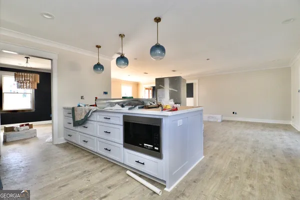 a large kitchen with stainless steel appliances a stove and a wooden floor