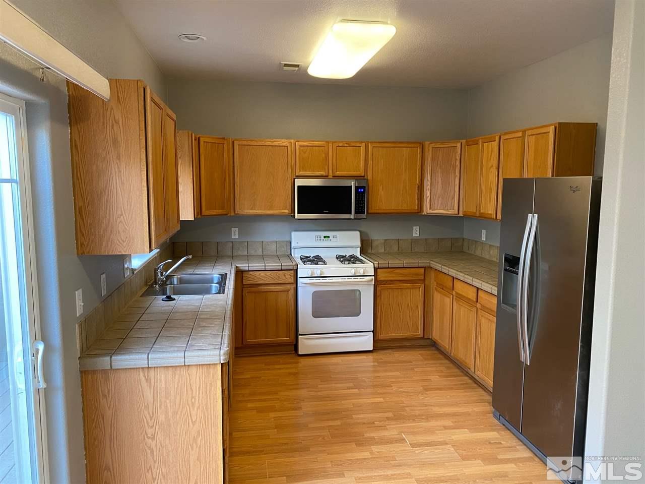 4150 Amber Marie Lane Reno, NV 89503 - Photo 5 of 16 a kitchen with a refrigerator sink and microwave