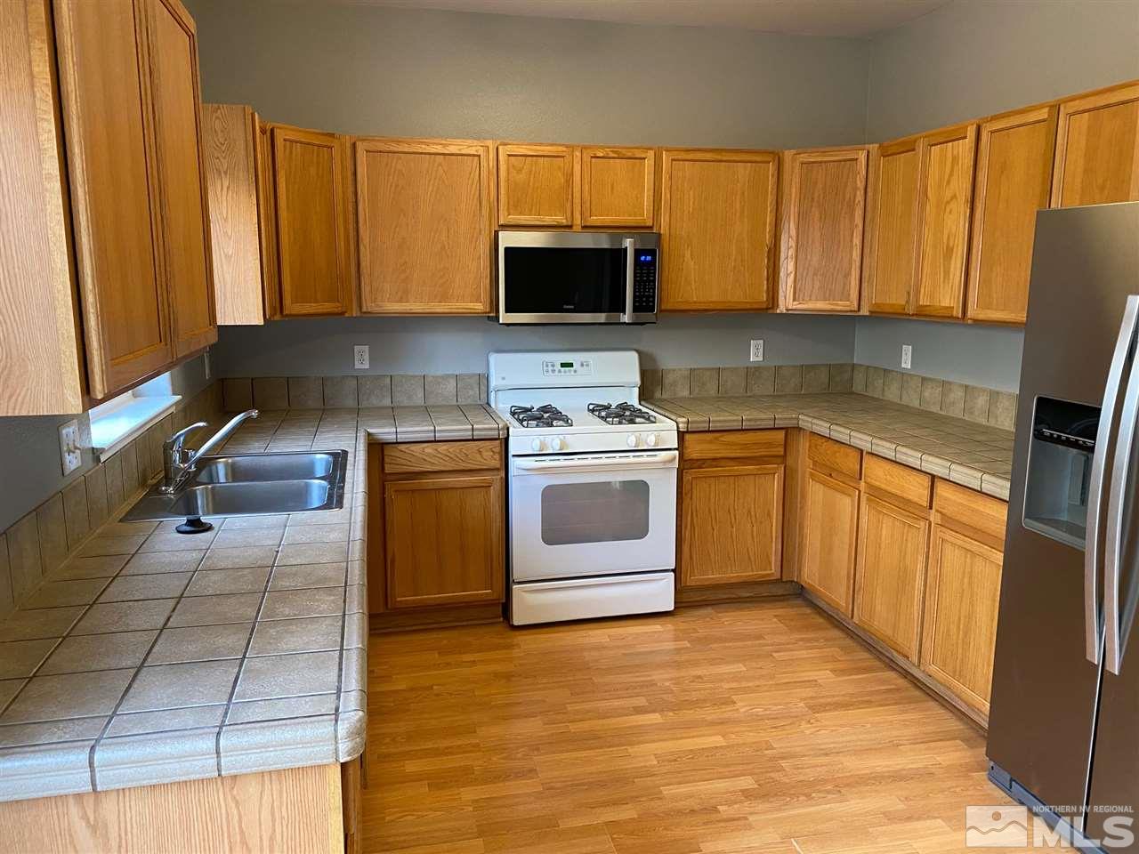 4150 Amber Marie Lane Reno, NV 89503 - Photo 6 of 16 a kitchen with a stove a sink and a microwave