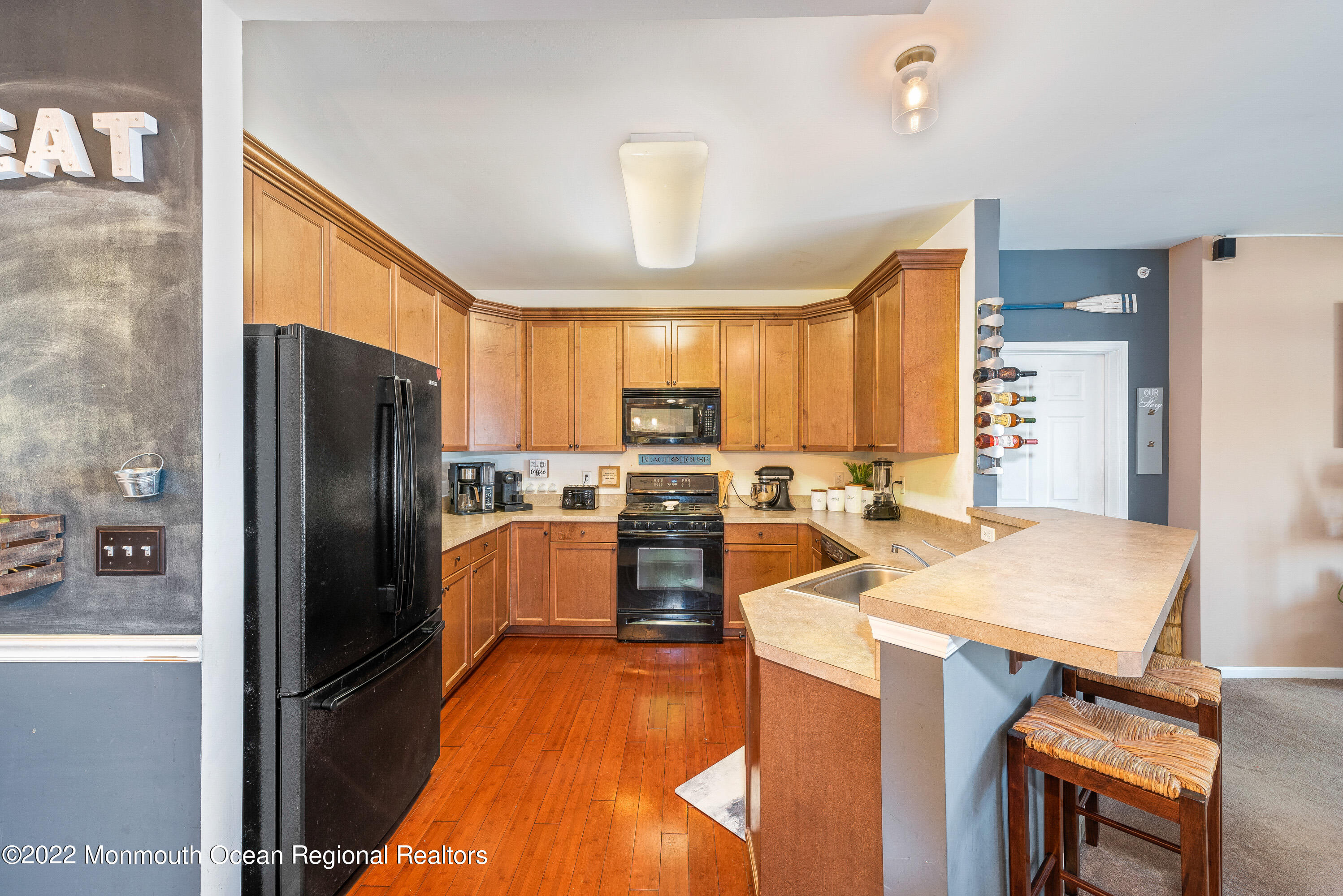 136 Mill Pond Way, Unit 22 Eatontown, NJ 07724 - Photo 14 of 29 a kitchen with stainless steel appliances wooden floor and large window