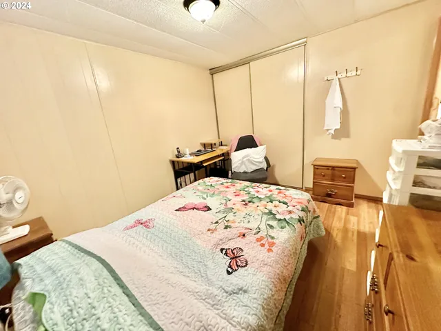 a bedroom with a bed and wooden floor