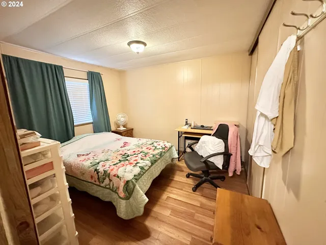 a bedroom with a bed and wooden floor