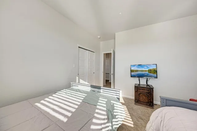 a bedroom with a large bed and a ceiling fan
