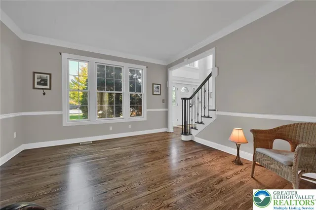 a kitchen with refrigerator and wooden floor