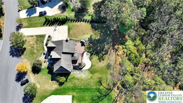 an aerial view of residential house with outdoor space and trees all around