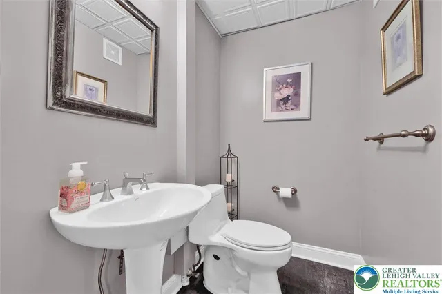 a bathroom with a granite countertop toilet sink and mirror