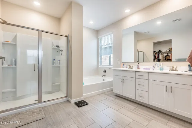 a spacious bathroom with a shower a sink and a mirror
