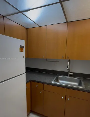 a kitchen with a sink and a refrigerator